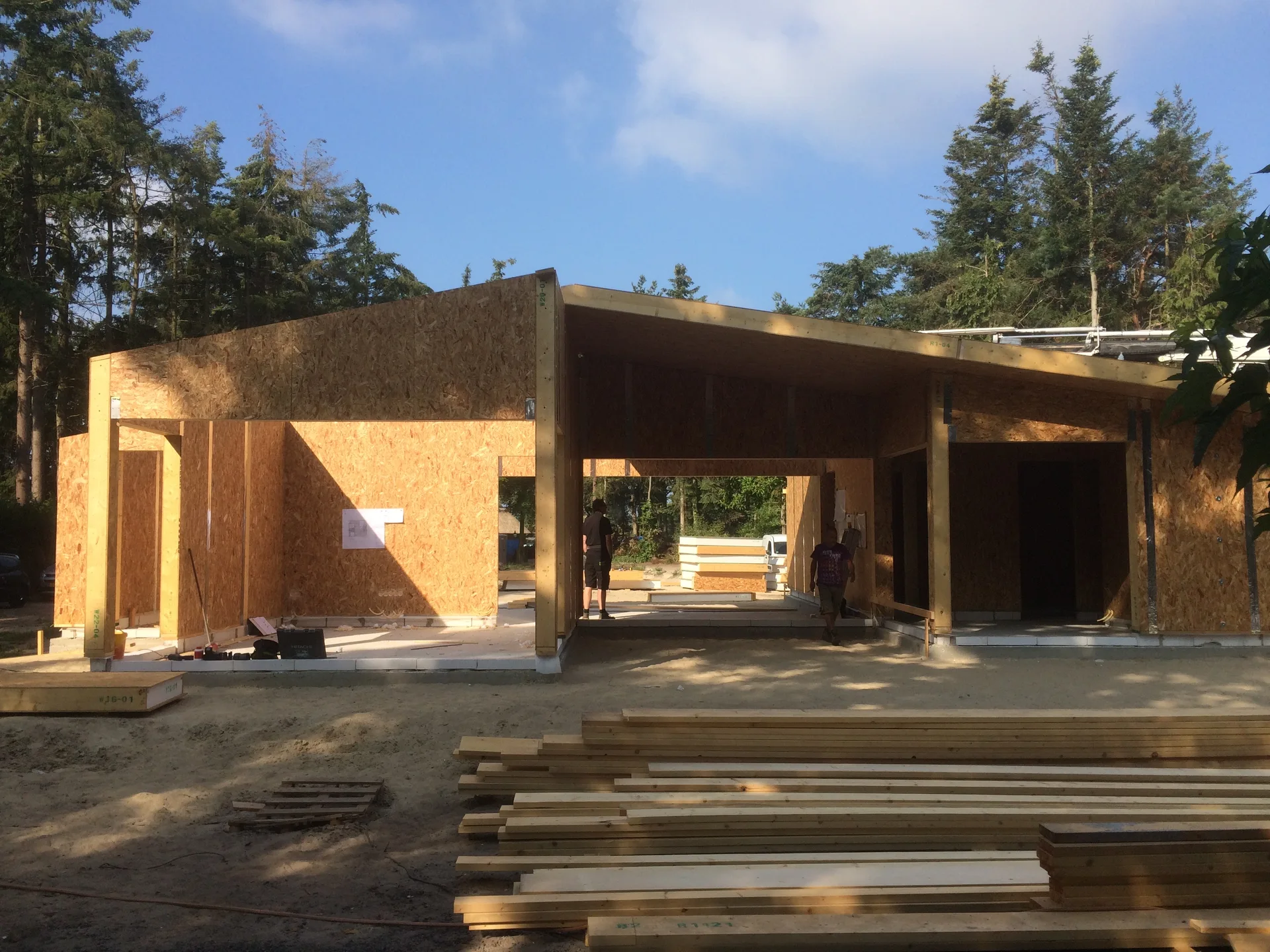 SIP shell with wall openings and timber components on site.